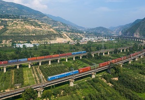 Two China Railways freight trains meet on the Longhai line near Yuanlong, between Tianshui and Baoji, China. Both trains are hauled by HXD1 locomotives